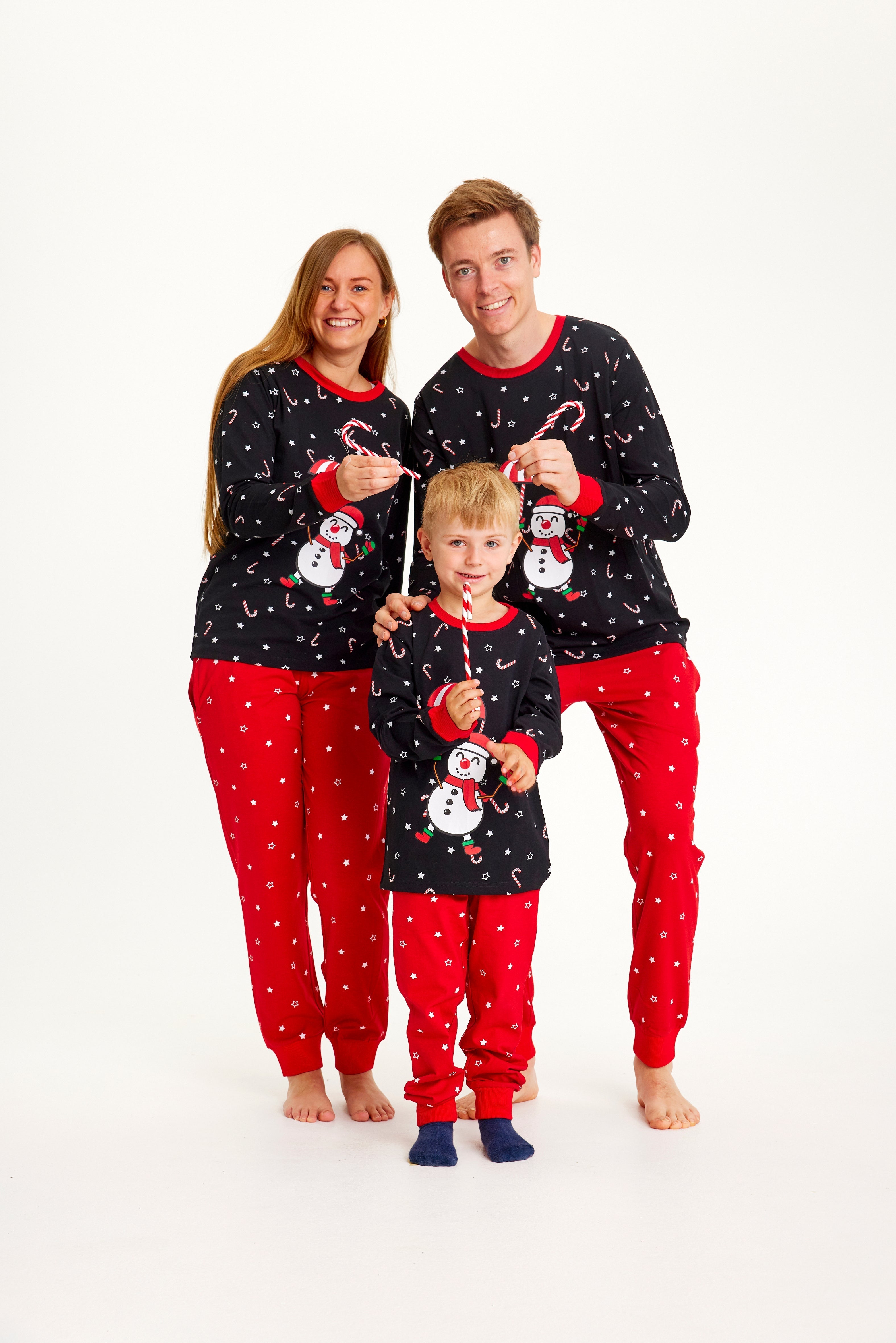 Une famille portant un pyjama de Noël noir et rouge avec un bonhomme de neige.
